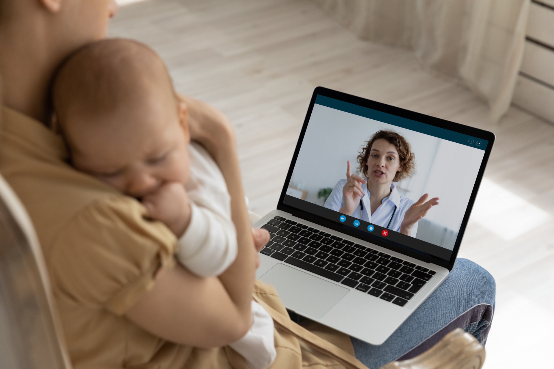 Mother holding baby during a telehealth visit with her Vye provider